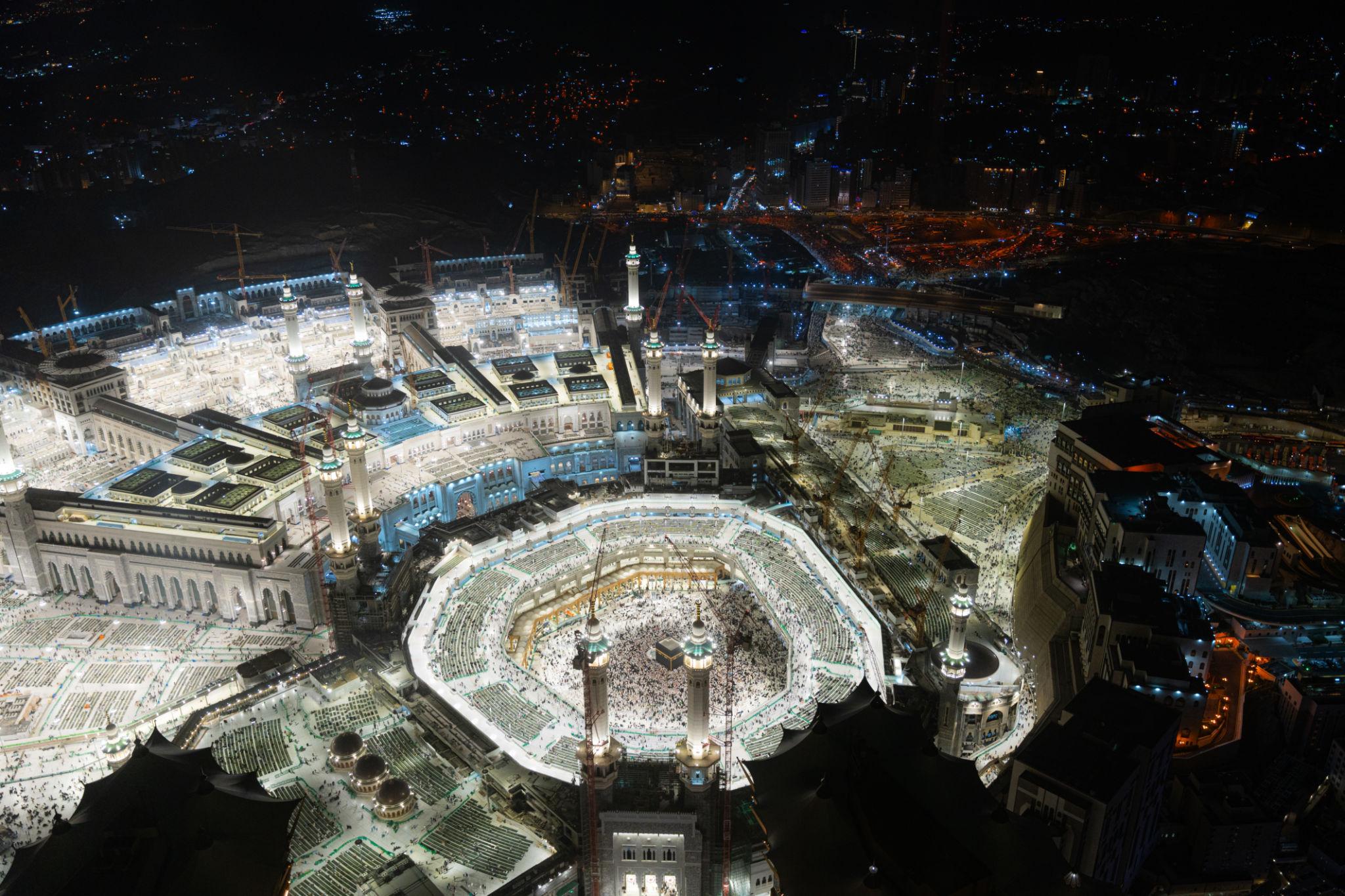 Masjid al-Haram illuminated at night.